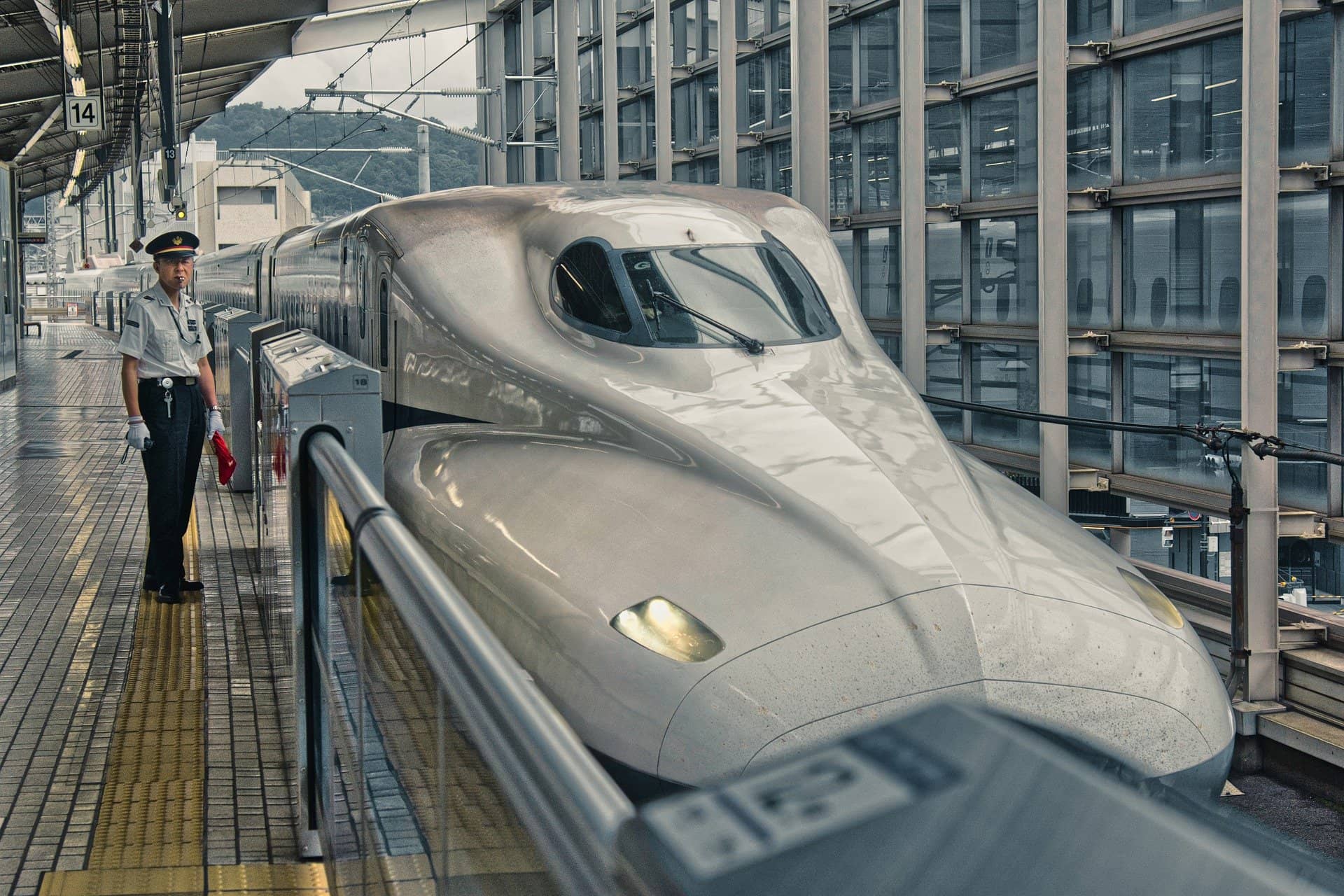 新幹線と車掌さんが映る駅構内の画像